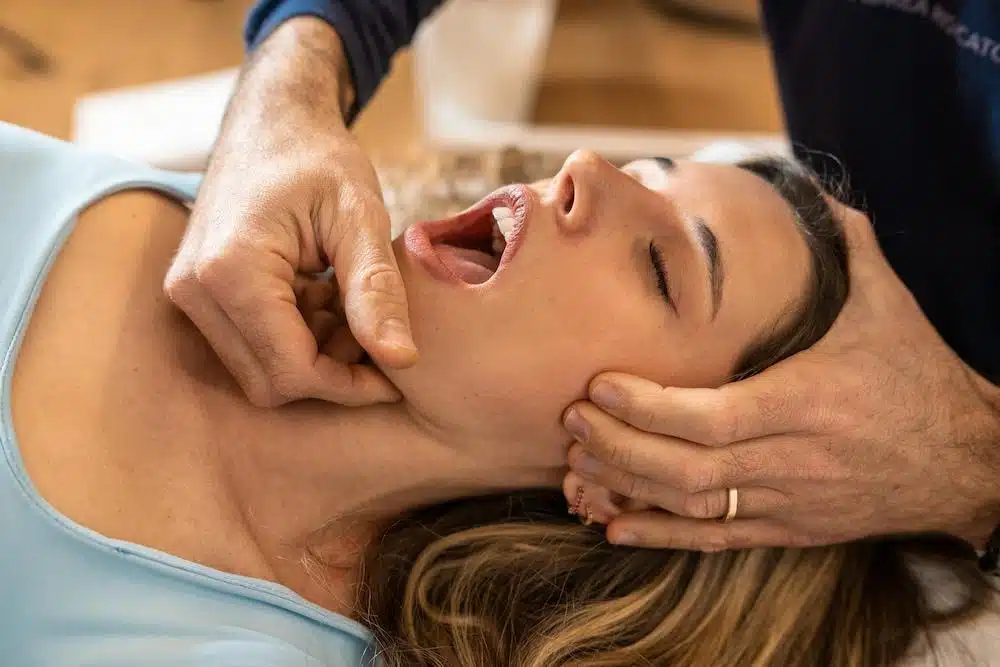 Woman with tmj disorder having some  treatment session with a chiropractor