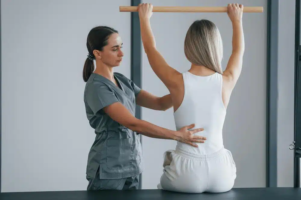 Chiropractor helping a patient to do some stretching and exercise 