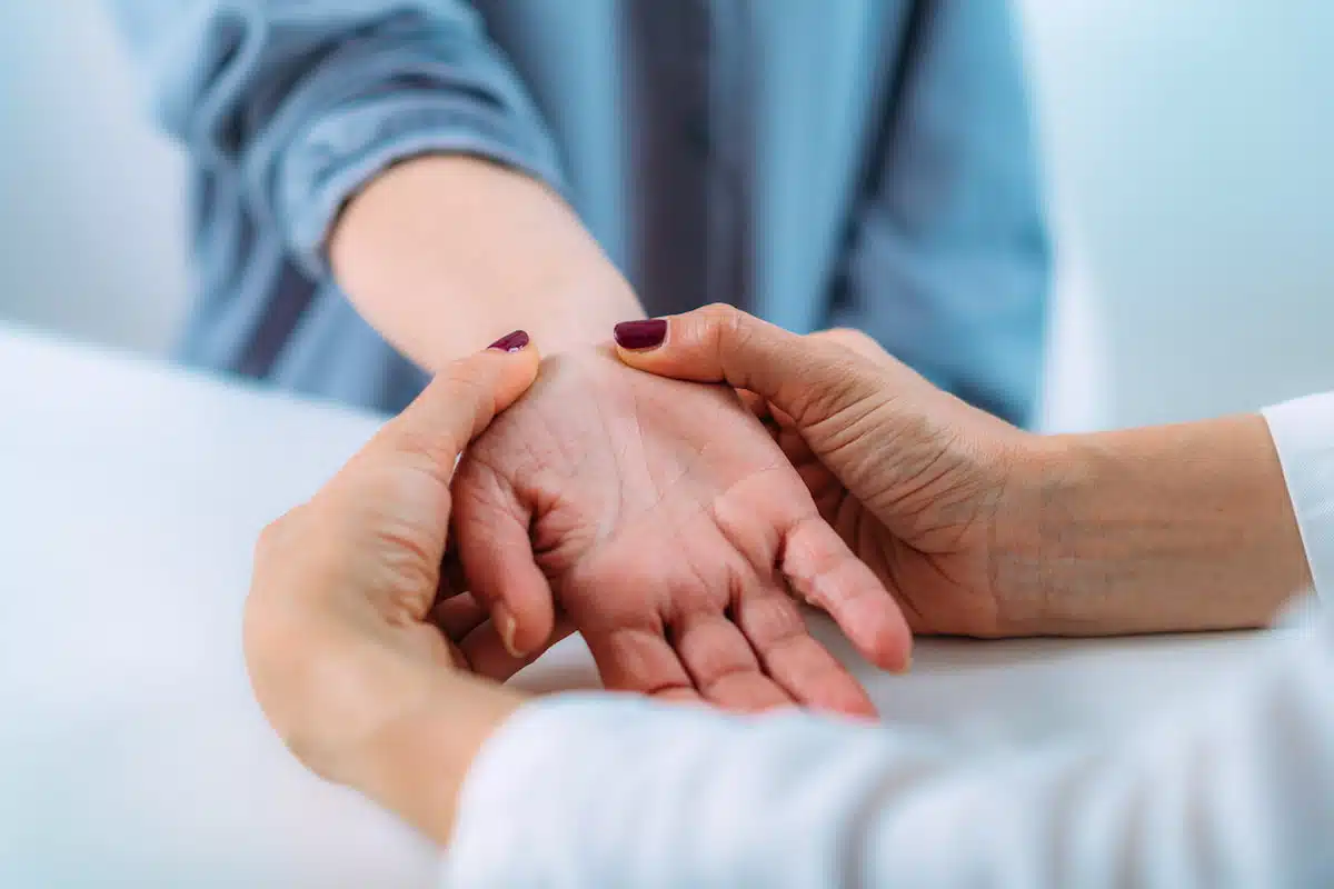 examining the hand of a senior patient with carpal