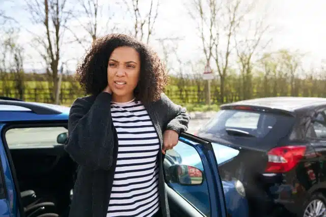 A woman having a whiplash after car accident